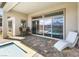 Covered patio seating area offers a serene view of the pool, spa, and picturesque lake backdrop at 160 Stone Mesa Ct, Henderson, NV 89011