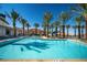 Beautiful swimming pool surrounded by palm trees and lounge chairs for relaxing by the water at 160 Stone Mesa Ct, Henderson, NV 89011