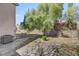 Landscaped backyard with mature tree, rock wall, and a seating area for outdoor relaxation at 1800 Montvale Ct, Las Vegas, NV 89134