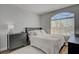 Bright bedroom features a queen bed, wood floors, and a large arched window with neighborhood views at 1800 Montvale Ct, Las Vegas, NV 89134