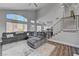 Bright living space featuring an open floor plan, modern staircase, and comfortable gray sectional at 1800 Montvale Ct, Las Vegas, NV 89134