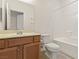 This full bathroom features a shower-tub combo, white tile, toilet, and wood-look vanity with sink at 2150 Grant Union Ct, Laughlin, NV 89029