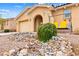 Front exterior featuring desert rock landscaping and charming front porch swing at 2150 Grant Union Ct, Laughlin, NV 89029