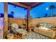 Comfortable outdoor lounge space featuring striped seating around a fire pit with wood plank flooring and block wall at 2264 Pacini Ct, Henderson, NV 89052