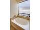 A soaking tub is framed by a frosted window and granite surround at 2300 S Washoe Ave, Pahrump, NV 89048