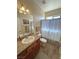 Bathroom with a granite vanity, wood cabinets, and shower with curtain at 2300 S Washoe Ave, Pahrump, NV 89048