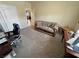 Another view of carpeted bedroom with desks, sofa, and a ceiling fan at 2300 S Washoe Ave, Pahrump, NV 89048