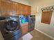 This laundry room features gray front load washer and dryer, cabinets, and tile flooring at 2300 S Washoe Ave, Pahrump, NV 89048