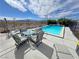 Backyard with pool, mountain views, surrounded by a wrought iron fence and patio furniture at 2300 S Washoe Ave, Pahrump, NV 89048