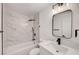 Bathroom with marble tiled walls, black fixtures, a modern vanity, and a shower and bathtub combination at 2521 Richfield Blvd, Las Vegas, NV 89102