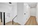 Hallway with modern lighting leads to a staircase with metal cable railing, a front door, and access to other rooms at 2521 Richfield Blvd, Las Vegas, NV 89102