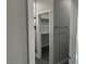 Well-lit bathroom featuring a glass shower door and a doorway leading to closet space at 2530 S Tecumseh Ave, Pahrump, NV 89048