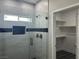 Stylish bathroom with glass shower enclosure with gray and black tile and a closet door at 2530 S Tecumseh Ave, Pahrump, NV 89048