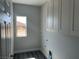 This well-lit laundry room features overhead cabinets, a window, and ample space for laundry tasks at 2530 S Tecumseh Ave, Pahrump, NV 89048