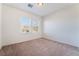 Bright bedroom with neutral carpet, white walls, and a window overlooking the backyard at 2743 Carolina Blue Ave, Henderson, NV 89052