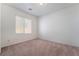 Cozy bedroom with neutral carpet, white walls, and a window overlooking the street at 2743 Carolina Blue Ave, Henderson, NV 89052
