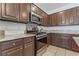 Kitchen with stainless steel oven, granite countertops, and dark wood cabinets at 2743 Carolina Blue Ave, Henderson, NV 89052
