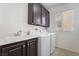 Functional laundry room with washer, dryer, sink, and built-in cabinets at 2743 Carolina Blue Ave, Henderson, NV 89052