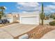 Exterior view showcasing an attached two-car garage with desert landscaping and additional parking space at 2812 Mirage Rd, Henderson, NV 89074