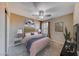Comfortable bedroom with soft carpet, ceiling fan, and natural light; features modern decor and neutral tones at 2844 Alenga St, Henderson, NV 89044