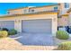 Two-car garage with grey doors, neat landscaping, and a paved driveway at 2844 Alenga St, Henderson, NV 89044