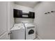 A functional laundry room includes washer, dryer, and cabinet storage at 2844 Alenga St, Henderson, NV 89044