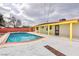 Inviting backyard featuring a swimming pool, patio area, and red brick privacy fence at 3008 Lawndale St, Las Vegas, NV 89121