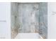 Luxury bathroom featuring stone-look tile tub/shower, modern rainfall shower head and fixtures at 3008 Lawndale St, Las Vegas, NV 89121