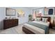Staged bedroom featuring a bed with a blue throw, dresser, and modern decor at 3008 Lawndale St, Las Vegas, NV 89121