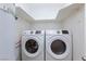 Convenient laundry area with modern, white front-load washer and dryer and overhead storage space at 3008 Lawndale St, Las Vegas, NV 89121