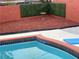 Outdoor pool area with a decorative brick wall and a manicured green hedge at 3008 Lawndale St, Las Vegas, NV 89121