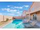 Refreshing backyard pool features built-in seating, lounge chairs, desert landscaping and a secure fenced enclosure at 304 Jolly January Ave, Las Vegas, NV 89183