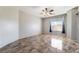An empty bedroom features neutral walls, decorative ceiling fan, and large window providing natural light at 304 Jolly January Ave, Las Vegas, NV 89183