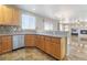 A modern kitchen features wood cabinets, stainless steel appliances, and granite countertops, seamlessly flowing into the living area at 304 Jolly January Ave, Las Vegas, NV 89183