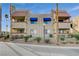 Condo complex showcasing a beige color scheme, blue awnings, and well-maintained landscaping at 4140 Gannet Cir # 255, Las Vegas, NV 89103