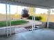 Cozy backyard featuring a covered patio, well-maintained lawn, mature tree, and gravel landscaping at 4194 Greenpoint St, Las Vegas, NV 89147
