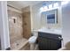 Bathroom features a walk-in shower with a tiled wall, and a sink with gray cabinets at 4194 Greenpoint St, Las Vegas, NV 89147
