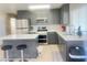 Modern kitchen with stainless steel appliances, gray cabinets, and a quartz countertop island with bar stool seating at 4194 Greenpoint St, Las Vegas, NV 89147
