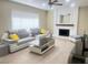 Cozy living room with a white brick fireplace, modern furniture, and plank flooring at 4194 Greenpoint St, Las Vegas, NV 89147