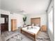 Staged bedroom with a modern ceiling fan, light wood floors, and a door that leads into the bathroom at 45 Maleena Mesa St # 327, Henderson, NV 89074