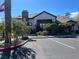 View of the community clubhouse with a stone chimney, landscaping, and ample parking at 45 Maleena Mesa St # 327, Henderson, NV 89074