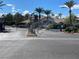 Main gate to the community, featuring mature landscaping and a stone monument at 45 Maleena Mesa St # 327, Henderson, NV 89074