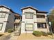 Exterior view of a condo building with stairs leading to upper-level units and multiple parking spaces in the area at 45 Maleena Mesa St # 327, Henderson, NV 89074