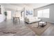 Bright, staged living room boasts modern decor, light wood floors, neutral colors, and natural light from the large windows at 45 Maleena Mesa St # 327, Henderson, NV 89074