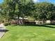 A grassy park area featuring mature trees, walking paths, and a playground at 45 Maleena Mesa St # 327, Henderson, NV 89074
