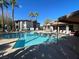 Community pool area, featuring lounge chairs, palm trees, and nearby residential buildings at 45 Maleena Mesa St # 327, Henderson, NV 89074