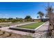 Well maintained bocce ball courts surrounded by palm trees, landscaping, and clear blue skies at 4743 S Sungold St, Pahrump, NV 89061