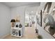 Well-lit hallway showcasing neutral walls, tile flooring, and decorative artwork, leading to a bright living area at 4743 S Sungold St, Pahrump, NV 89061