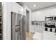 Kitchen boasts stainless steel appliances, white cabinetry, and tile backsplash at 4743 S Sungold St, Pahrump, NV 89061