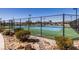 Outdoor tennis courts featuring fencing, lighting, and lush landscaping for an active lifestyle at 4743 S Sungold St, Pahrump, NV 89061